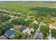 Community aerial view shows homes nestled among mature trees with solar panels at 15110 Kestrelglen Way, Lithia, FL 33547