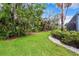 Lush green backyard with manicured lawn and tropical foliage provides a private oasis at 15110 Kestrelglen Way, Lithia, FL 33547