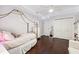 Comfortable bedroom featuring hardwood floors, soft lighting, and white trim at 15110 Kestrelglen Way, Lithia, FL 33547