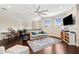 Bright bonus room featuring dark hardwood floors, comfortable white couch, and work space at 15110 Kestrelglen Way, Lithia, FL 33547