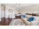 Large bonus room with white leather sofa, desk, and plush accent rug on dark hardwood floors at 15110 Kestrelglen Way, Lithia, FL 33547