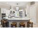 Bright kitchen boasts white cabinets, a marble island with seating, and stainless steel appliances at 15110 Kestrelglen Way, Lithia, FL 33547