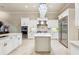 Bright kitchen with an island, white cabinetry, stainless steel appliances, and a modern chandelier at 15110 Kestrelglen Way, Lithia, FL 33547