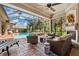 Inviting lanai with a fireplace, comfortable seating, and a view of the sparkling pool and lush backyard at 15110 Kestrelglen Way, Lithia, FL 33547