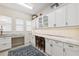 Bright laundry room featuring marble countertops, stylish cabinetry, and a convenient desk area at 15110 Kestrelglen Way, Lithia, FL 33547