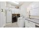 Functional laundry room with modern appliances, built-in cabinets, sink, and a stylish countertop at 15110 Kestrelglen Way, Lithia, FL 33547