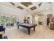 This elegant living room boasts an open floor plan, coffered ceilings, and access to an outdoor pool area at 15110 Kestrelglen Way, Lithia, FL 33547