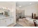 Bright main bathroom featuring a soaking tub, walk-in shower, and dual vanities at 15110 Kestrelglen Way, Lithia, FL 33547