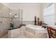 Main bathroom showcasing a soaking tub, walk-in shower, and neutral color palette at 15110 Kestrelglen Way, Lithia, FL 33547