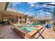 Inviting screened-in pool and spa, outdoor kitchen, and comfortable patio seating create an ideal entertainment space at 15110 Kestrelglen Way, Lithia, FL 33547