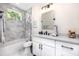 Modern bathroom featuring marble tile, a tub-shower, white vanity with black hardware and lighting at 1529 N Morgan St, Tampa, FL 33602