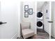 Convenient laundry area with stacked washer and dryer, adjacent to a chair and hallway at 1529 N Morgan St, Tampa, FL 33602