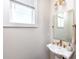 Chic powder room with pedestal sink, bronze fixtures and ample natural light at 1529 N Morgan St, Tampa, FL 33602