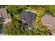 A well-maintained home with a backyard pool, lush landscaping, and dark roof in a serene neighborhood at 15934 Sorawater Dr, Lithia, FL 33547