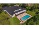 Aerial view of a beautiful home with a pool and covered patio in a lush, green neighborhood at 15934 Sorawater Dr, Lithia, FL 33547