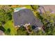 A well-maintained home featuring a dark roof, lush landscaping, and a backyard pool for outdoor enjoyment at 15934 Sorawater Dr, Lithia, FL 33547
