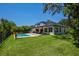 Expansive backyard with lush lawn, sparkling pool, and outdoor living space perfect for entertaining at 15934 Sorawater Dr, Lithia, FL 33547
