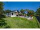 A luxurious backyard featuring a sparkling pool, manicured lawn, covered patio, and privacy fence at 15934 Sorawater Dr, Lithia, FL 33547
