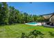 Serene backyard featuring a private pool, well-maintained lawn, and mature trees at 15934 Sorawater Dr, Lithia, FL 33547