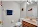 Cozy half bathroom with neutral walls, wood vanity, and decorative towel rack at 15934 Sorawater Dr, Lithia, FL 33547