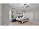 Cozy bedroom features a ceiling fan, white walls, carpet, and a large window at 15934 Sorawater Dr, Lithia, FL 33547