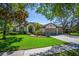 Charming home featuring a well-manicured lawn, mature trees, and an inviting three-car garage at 15934 Sorawater Dr, Lithia, FL 33547