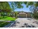 This home boasts a three-car garage, mature landscaping, and a well-maintained lawn at 15934 Sorawater Dr, Lithia, FL 33547