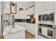 Kitchen featuring stainless steel appliances, modern lighting, and white cabinets with black backsplash at 15934 Sorawater Dr, Lithia, FL 33547