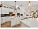 A spacious kitchen featuring a marble island, black backsplash, stainless steel appliances, and modern lighting at 15934 Sorawater Dr, Lithia, FL 33547