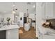 A spacious kitchen featuring a marble island, black backsplash, stainless steel appliances, and modern lighting at 15934 Sorawater Dr, Lithia, FL 33547