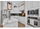 Modern kitchen with white cabinets, stainless steel appliances, large island with marble countertop and stylish lighting fixtures at 15934 Sorawater Dr, Lithia, FL 33547
