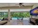 Covered outdoor patio with seating area overlooking the sparkling pool and lush backyard at 15934 Sorawater Dr, Lithia, FL 33547