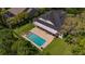 Aerial view of a backyard pool with a covered patio and well-maintained lawn at 15934 Sorawater Dr, Lithia, FL 33547