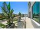 Modern balcony overlooking the street, showcasing glass railings and tropical landscaping at 16047 Redington Dr, Redington Beach, FL 33708