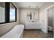 Modern bathroom featuring double vanity, a soaking tub, and sleek pendant lighting at 16047 Redington Dr, Redington Beach, FL 33708