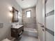 Modern bathroom featuring wood vanity, stylish mirror, and shower over tub with glass enclosure at 16047 Redington Dr, Redington Beach, FL 33708
