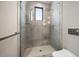 Contemporary bathroom features a walk-in glass shower with gray tile and a rainfall shower head at 16047 Redington Dr, Redington Beach, FL 33708