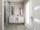 Modern bathroom features dual sinks, decorative shower glass, marble floors, and a bright window at 16047 Redington Dr, Redington Beach, FL 33708