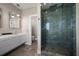 Modern bathroom with glass walk-in shower, marble-style tiling, and vanity sink at 16047 Redington Dr, Redington Beach, FL 33708