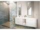 Modern bathroom featuring dual sinks, decorative shower glass, and marble floors at 16047 Redington Dr, Redington Beach, FL 33708
