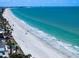 Scenic view of a pristine white sand beach with turquoise ocean waters, ideal for relaxation and recreation at 16047 Redington Dr, Redington Beach, FL 33708