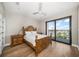Comfortable bedroom with a wooden bed, wood floors, and a water view through a glass door at 16047 Redington Dr, Redington Beach, FL 33708