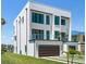 Modern three-story home with a balcony and spacious two-car garage at 16047 Redington Dr, Redington Beach, FL 33708