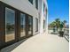 Exterior balcony featuring glass doors, railing, and tropical landscaping; great for outdoor enjoyment at 16047 Redington Dr, Redington Beach, FL 33708