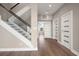 Modern foyer with wood floors, glass railing staircase, and decorative doors at 16047 Redington Dr, Redington Beach, FL 33708