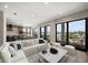 Open-concept living room with water views, modern furniture, and access to a balcony at 16047 Redington Dr, Redington Beach, FL 33708