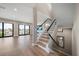 Open-concept living space with hardwood floors, staircase, and sliding glass doors at 16047 Redington Dr, Redington Beach, FL 33708