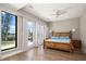 Bright main bedroom boasts a bamboo bed frame, light hardwood floors, and views of the community at 16047 Redington Dr, Redington Beach, FL 33708