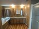 Well-lit bathroom with double glass vessel sinks, a soaking tub, and a separate glass-enclosed shower at 1710 7Th Sw St # 85, Ruskin, FL 33570