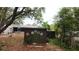 View of the backyard featuring a storage shed with colorful flower paintings and mature trees at 2033 Aaron Pl, Clearwater, FL 33760